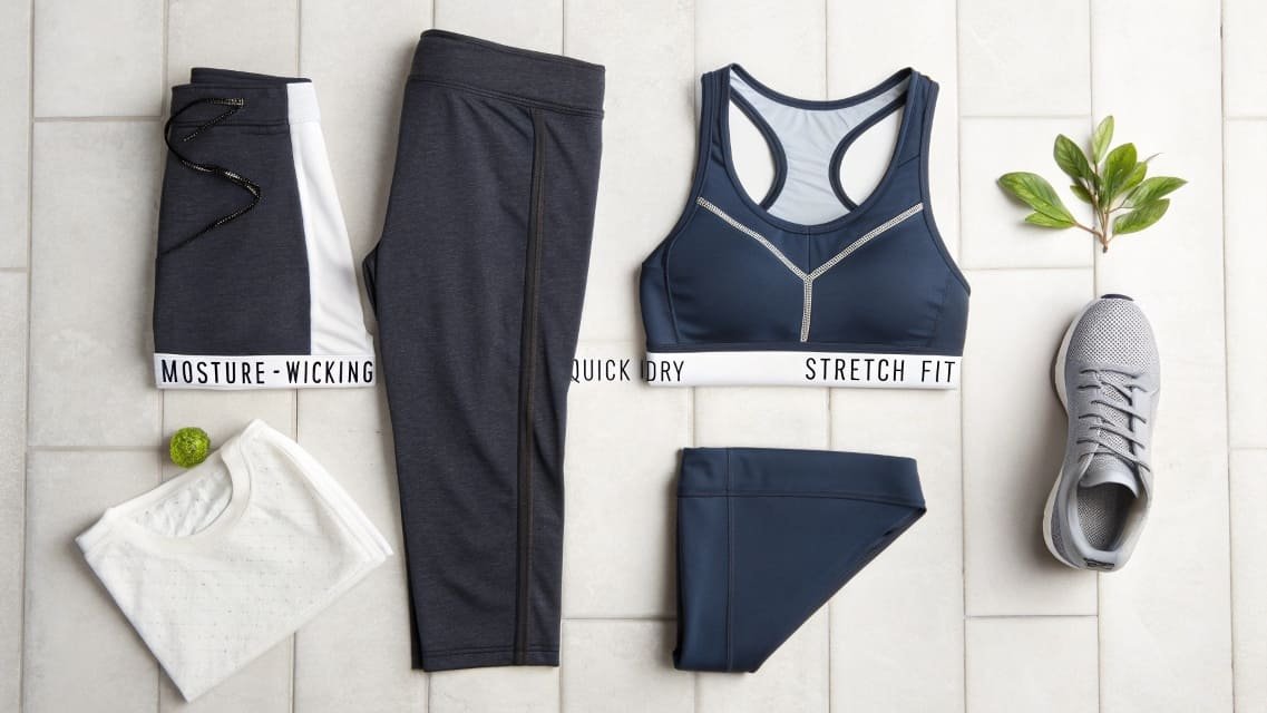 Flat lay of sports bra, leggings, shorts, t-shirt, and sneakers.