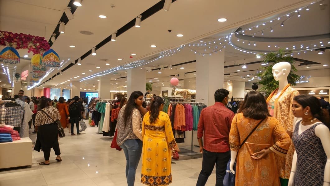 Shoppers browsing colorful garments in a fashion retail store