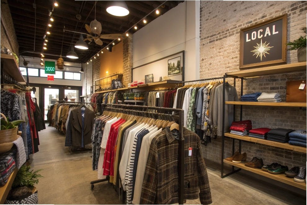 A clothing store interior with organized clothing displays, emphasizing local fashion.