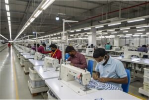 Workers sewing garments on industrial sewing machines in factory