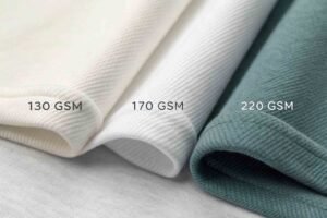 Close-up of fabrics with different GSM weights labeled 130, 170, and 220.