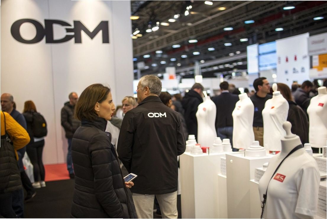 Visitors exploring ODM booth at a fashion trade show