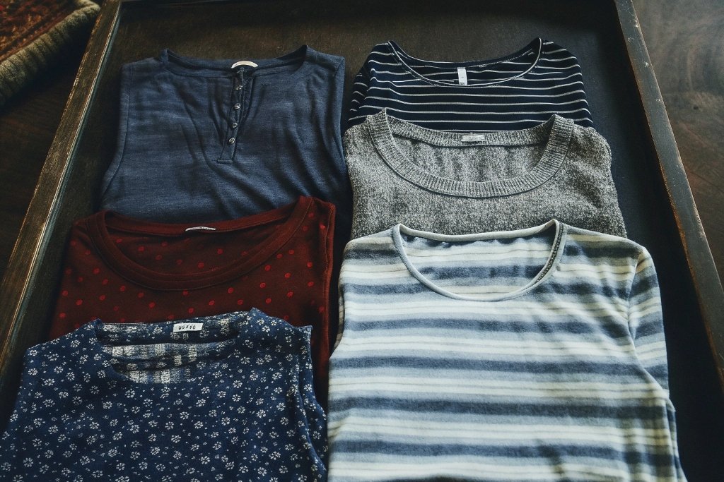 Collection of folded women’s tops in various colors and patterns.